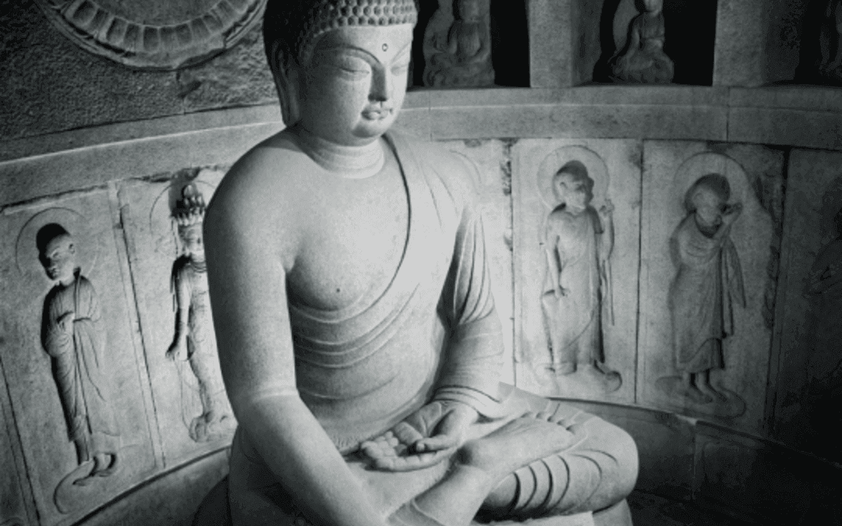 Il Buddha di Seokguram, statua monumentale in pietra raffigurata all’interno della grotta di Seokguram, in Corea del Sud. La figura è seduta in posizione meditativa, con gli occhi socchiusi e le mani raccolte in grembo; alle sue spalle sono visibili rilievi e statue scolpite nella pietra.