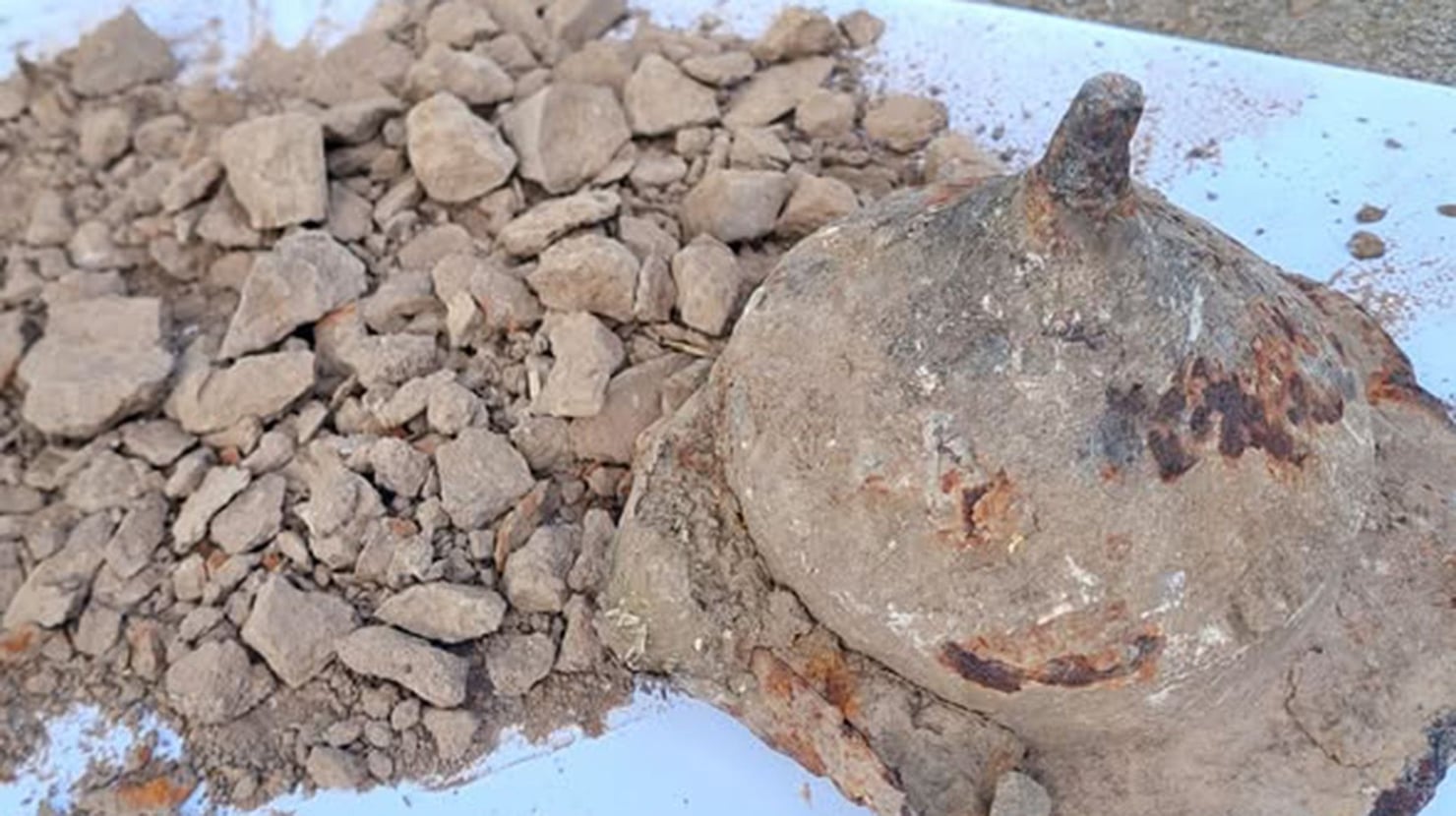 Un contenitore in pietra a forma di cono pieno di cenere grigia.