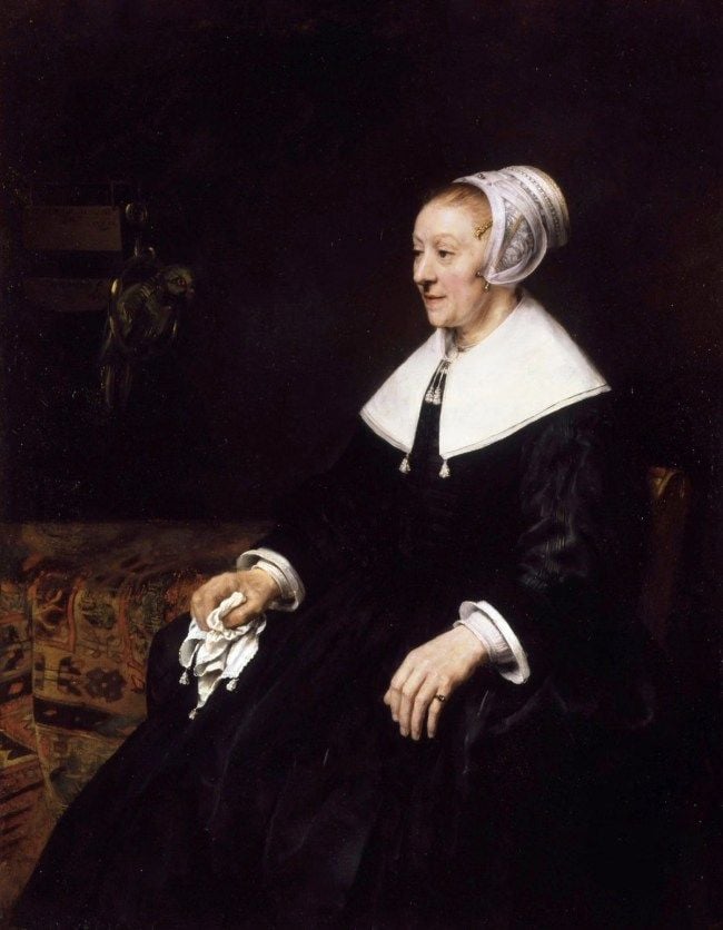 Ritratto di Catrina Hooghsaet di Rembrandt van Rijn: un'anziana donna con un vestito nero e un copricapo di pizzo bianco è seduta di profilo contro un interno scuro, stringendo in mano un fazzoletto bianco.