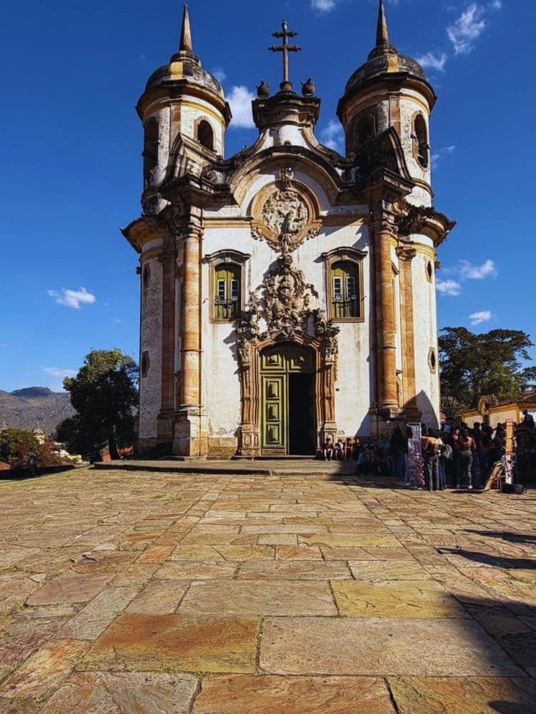 Facciata della Chiesa di San Francesco d’Assisi di Ouro Preto, capolavoro barocco progettato da Aleijadinho, con due torri laterali, ricche decorazioni scultoree e un ampio sagrato in pietra.